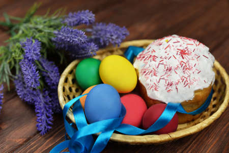 baking cake with icing glaze bread with eggs in a basket colored on a wooden background of flowers...
