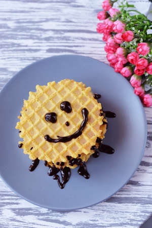 delicious breakfast waffles food with chocolate topping on a plate with flowers Ñ form smiley smileの写真素材