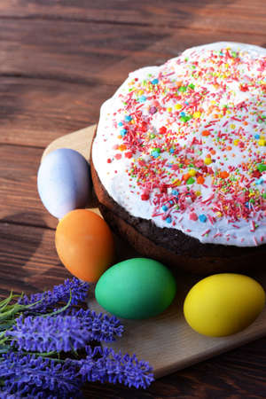 baking cake with icing glaze bread with eggs in a basket colored on a wooden background of flowers...