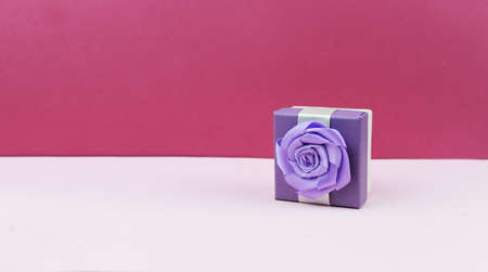 surprise box gift with a bow on a pink background for the holiday birthday Valentine's Day March 8...