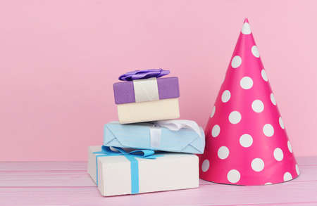 accessory cap hat for a holiday birthday with boxes of gifts on a pink backgroundの写真素材