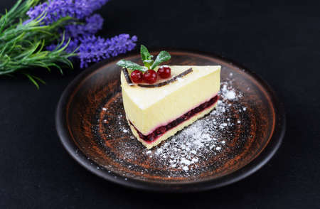 dessert cheesecake with mint and berries on a black background with flowers