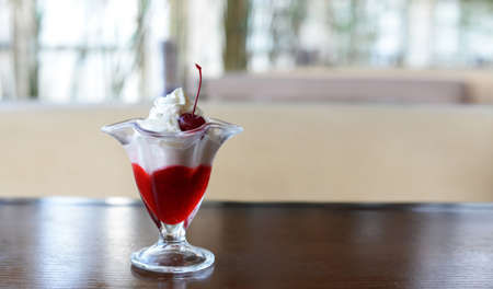 delicious dessert ice cream with cream and strawberries jam and cherry in the restaurantの写真素材