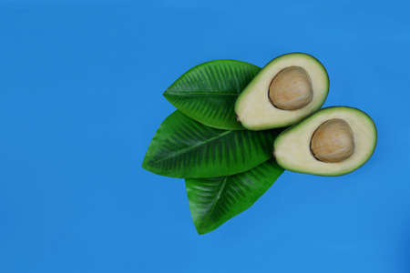 ripe fruit green avocado and a half on a blue backgroundの写真素材