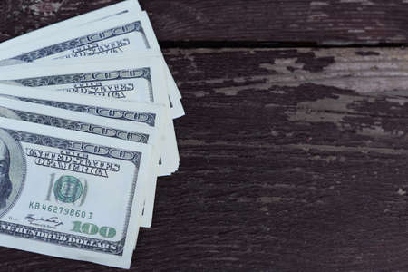 bills hundred dollars paper money to pay for a wooden backgroundの写真素材