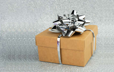surprise gift box on silver with bow background with bokeh closeup