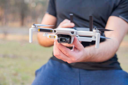 young man controls launches a modern drone for video and photoの写真素材