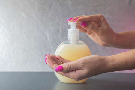 girl washes her hands with cosmetic liquid soap with a dispenser in a bottle