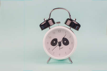 morning cute panda alarm clock on blue backgroundの写真素材