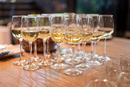 a lot of glasses with white wine in a restaurant at a buffet or banquet for a holidayの写真素材