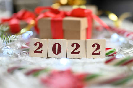 gift boxes on a knitted blanket with a bow with wooden numbers 2022 for new year and christmas
