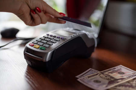 the girl uses the terminal to pay for cashless payments using the bank card systemの写真素材