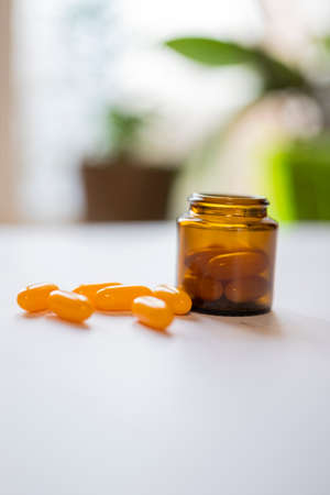 medication yellow pills capsules in a jarの写真素材