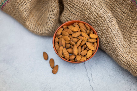 delicious brown almonds in a plateの写真素材