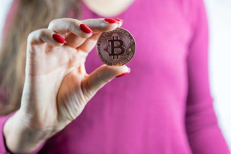 girl holding a metal gold digital internet trend cryptocurrency in her handの写真素材