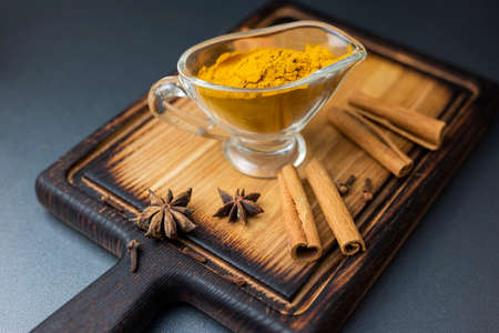 spicy dry turmeric with cinnamon sticks on a wooden boardの写真素材