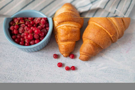 delicious sweet pastry croissant with red currant berry for breakfastの写真素材