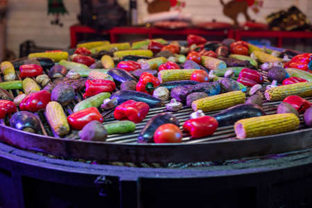 vegetables paprika with corn are prepared in a cauldron at the fair. street food fast food at the fairの写真素材