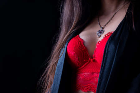 bust breasts of a girl in lingerie and a robe red bra with decoration pendant necklaceの写真素材