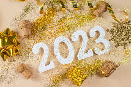 white numbers 2023 for the New Year holiday in December with glitter gold wooden cork and serpentine