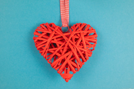 deor decoration made of wood in the shape of a heart on a blue background for the holiday of Valentine's Dayの写真素材