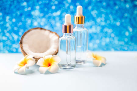 cosmetics in glass bottle with palm leaf and mango flowerの写真素材