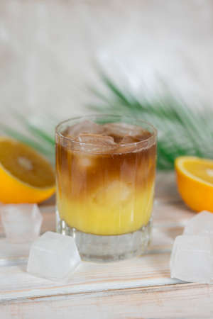 drink bumblebee bumble in a glass. Coffee with orange juice with ice and orange fruitsの写真素材
