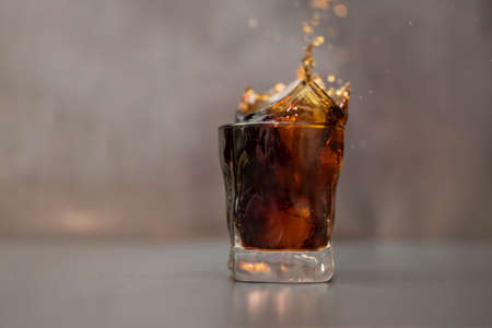 drink soda in a glass poured with splashesの写真素材