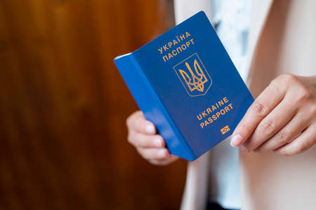 a girl holds a passport of ukraine in her handsの写真素材