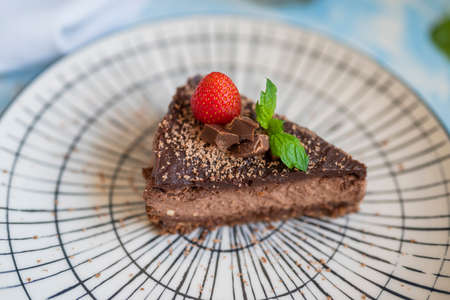 delicious chocolate dessert in a restaurant cheesecake with strawberries and mint leafの写真素材