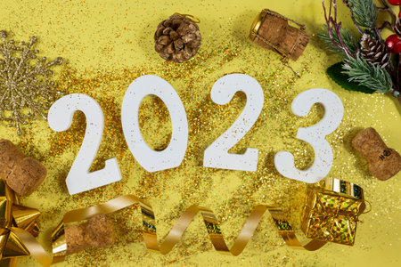 white numbers 2023 for the New Year holiday in December with glitter gold wooden cork and serpentine