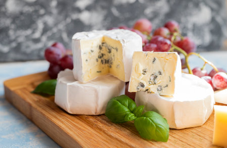 delicious blue brie blue cheese with grapes on a wooden board