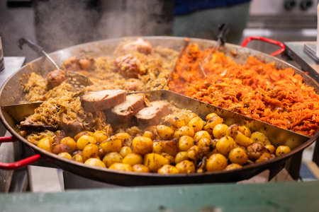 vendor fries meat and sausage and potato on the grill in the city center at the Christmas market in Gdansk Polandの写真素材