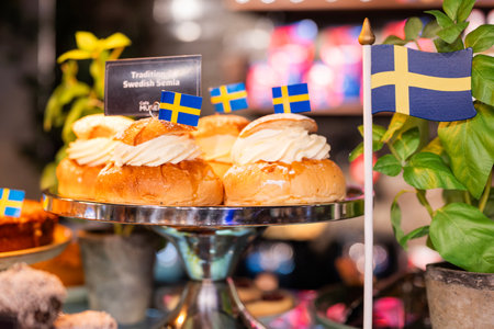 s swedish national tasty pastries sweet food in stockholm with flags in cafe with semla buns display case. text "traditional swedish semla"の写真素材
