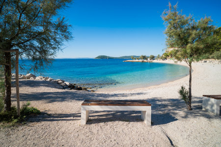 a beautiful beach with a view of the Adriatic Sea with rocks on the shore and pine trees in Split, Croatiaの写真素材