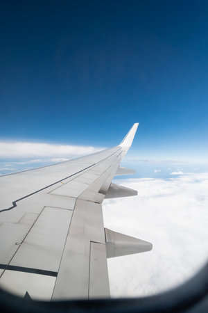 view from the window of an airplane in flight on clouds with the wing of a airplane