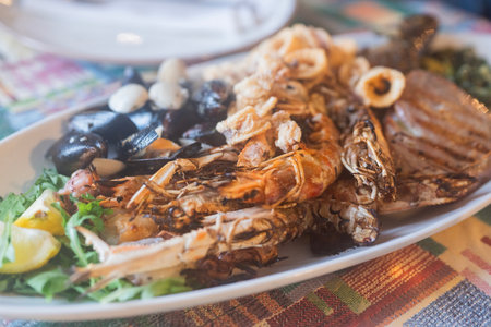 A plate of seafood with mussels, shrimp, and fried squidの写真素材