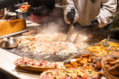vendor fries meat on the grill in the city center at the Christmas market in Krakow Poland