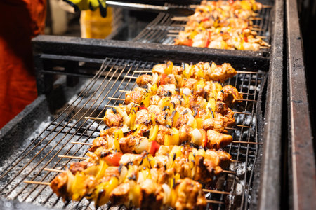 the seller fries meat kebabs at the festival. street fast food
