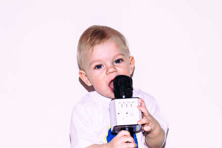 Little boy of 9 months sits on the floor with a microphone.の写真素材