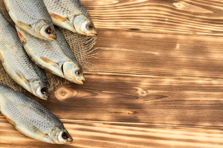 dry fish on a wooden background with space for textの写真素材