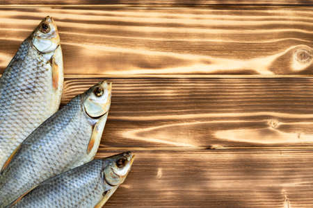 dry fish on a wooden background with space for textの写真素材