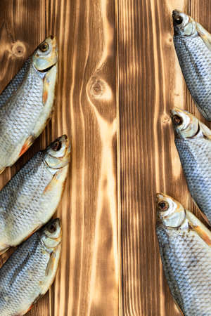 dry fish on a wooden background with space for text