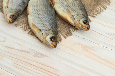 dry fish on a white wooden background with room for textの写真素材