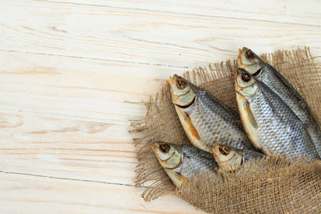 dry fish on a white wooden background with room for text