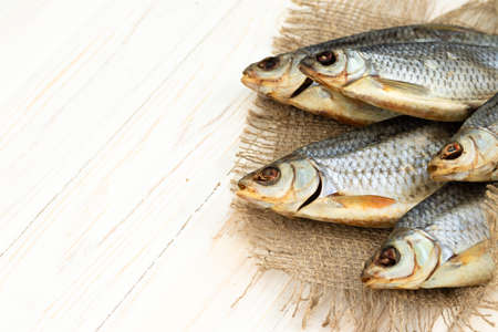 dry fish on a white wooden background with room for text