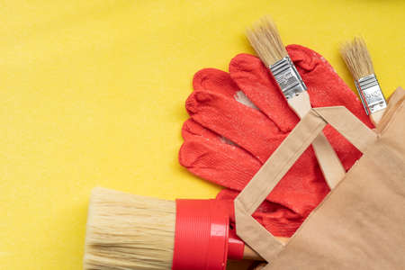 brushes for painting in a paper bag on a yellow background
