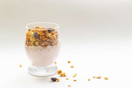 breakfast muesli in a glass with yogurt on a white background.copy spase
