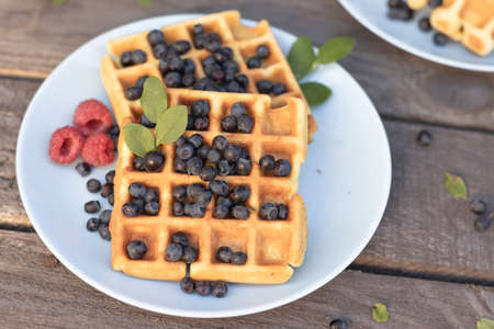 waffles Belgian mix of blueberries raspberries on a wooden background.の写真素材