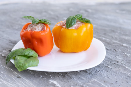 raw pepper stuffed with meat with basil on a white plateの写真素材